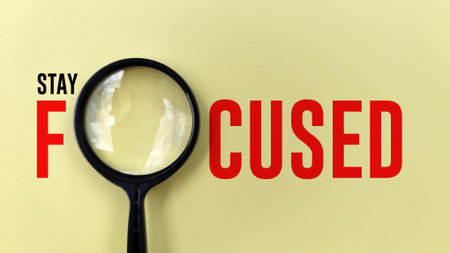 Stay Focused typography with magnifying glass on yellow background. motivational quote. focus conceptの写真素材