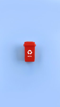 Red recycle bin for separate metal waste isolated on blue background. Recycle conceptの写真素材