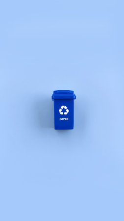 Blue recycle bin for separate paper waste isolated on blue background. Recycle conceptの写真素材