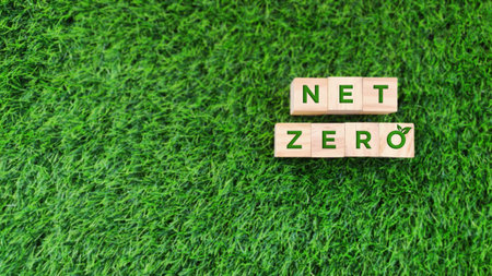 wooden block with NET ZERO green text on grass background. sustainability, environmental conceptの写真素材