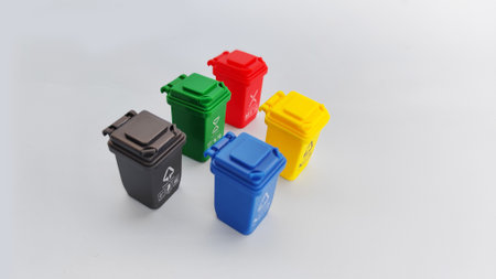 Set of multicolored recycle bins displayed in different organized layout on grey surfaces. Ideal for...