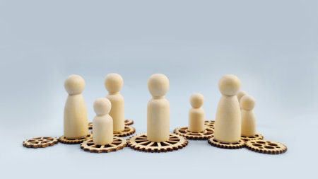 Wooden figures standing on gear shapes representing leadership, organization, roles, and business...