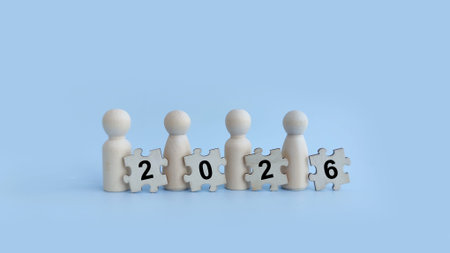 Wooden figures holding 2026 puzzle pieces representing future planning and business vision.