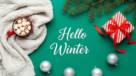 Hello Winter lettering with cup of hot chocolate, gift box and Christmas tree branches on green backgroundの素材