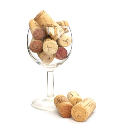 Wine glass filled with wine corks on white backgroundの写真素材