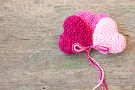 knitted valentine s hearts on a cracked old wooden texture の写真素材