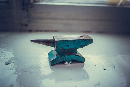 Small old rusty blue anvil from table vise.の写真素材