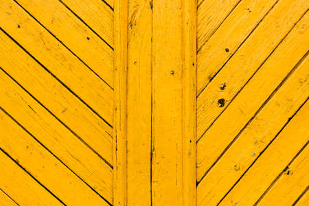 Obsolete yellow painted wooden background texture. Outdoor, macro.
