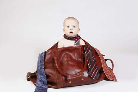 Baby boy sitting in a bag wearing a tiesの写真素材