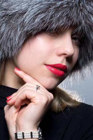 Beautiful girl with red lips in fur hatの写真素材