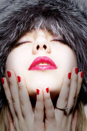 Beautiful girl with red lips in fur hatの写真素材