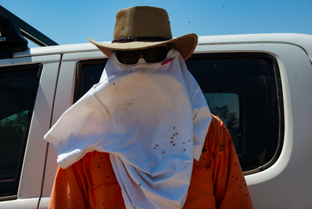 A surveyor works in the Australian outback trying to cope with the flies and heatのeditorial素材