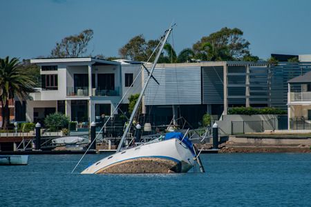 The remnants of a tropical storm left a few yachts and boats in trouble in Molloolaba. Here a yacht has partially sunk in the high windsのeditorial素材