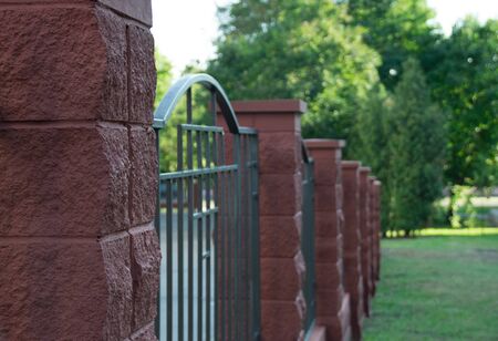 Stone and iron fence. Sharp first plan and blur background.の写真素材