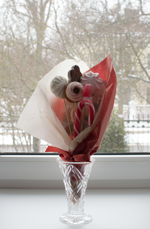 Candy bouquet orange wall background. Natural light and view througt windowの写真素材