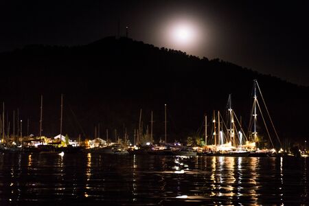Small city and harbor at night. Sea and lights. Clear sky in Turkeyの写真素材