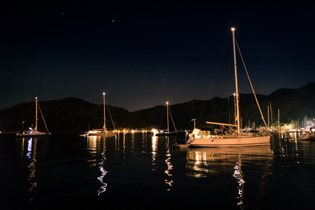 Small city and harbor at night. Sea and lights. Clear sky in Turkeyの写真素材