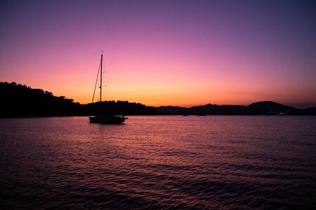 Sunset evening and yacht in calm bayの写真素材