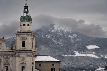 Cloudy Salzburg rooftop view, historical architecture, mountains, Austria winter.の写真素材
