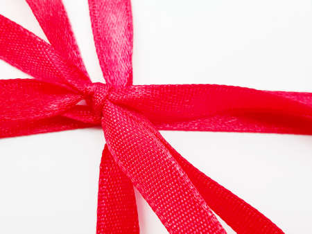 Red ribbon bows are used as gifts on special days on white backgroundの写真素材