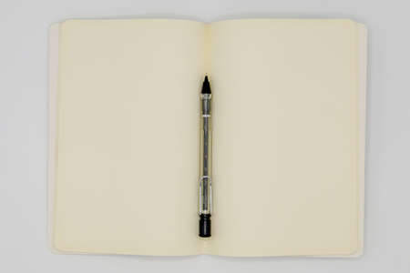 Open notebook and pencil on white background
