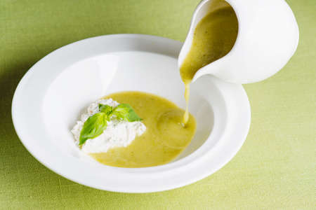 Soup of green vegetables with fresh herbs and cottage cheeseの写真素材