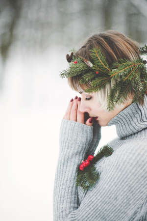 Portrait of a beautiful young woman in winter forestの写真素材