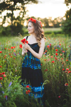 Beautiful young woman on the poppy fieldの写真素材