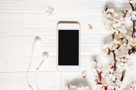 White wooden desktop with modern smart phone