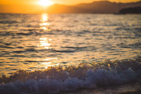 Sea waves and ripples at sunset backgroundの写真素材