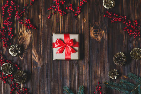Christmas presents box with red ribbon on a wooden table backgroundの写真素材
