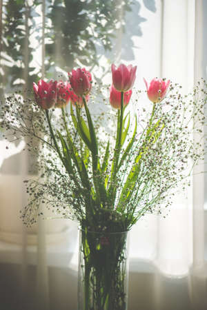 Fresh pink tulip bouqet on the table on sunny day