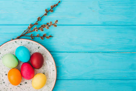 Easter eggs in plate on blue wooden table backgroundの写真素材