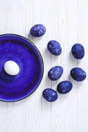 Ultra violet marble easter eggs on white wooden background. Flat lay style