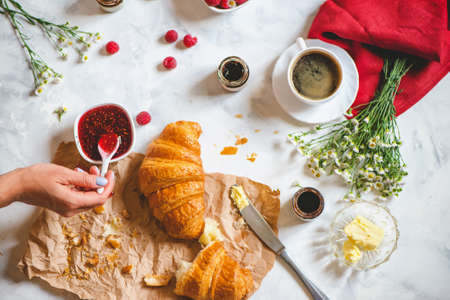Fresh continental breakfast with croissant, coffee, jam, and butter. Rustic style. Top viewの写真素材