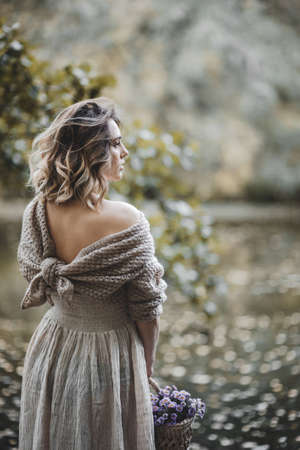 Romantic woman in a knit sweater near the lake in autumn parkの写真素材
