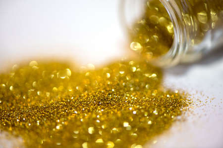 Gold glitter spilles from glass jar. Holidays conceptの写真素材