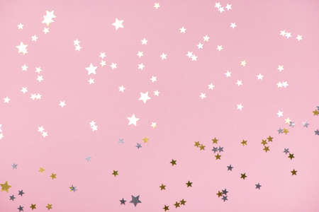 Golden stars glitter on trendy pink pastel background.