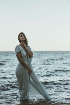 Young beautiful woman standing in waterの写真素材