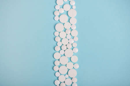 Vertical row of white pills on blue background with copy space