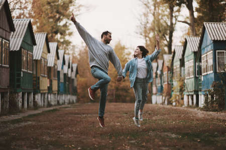 Lovely couple having fun jumping and laughing outdoorsの写真素材