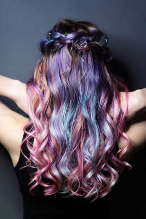 Back view of young woman with modern hairstyle. Colorful haircut.