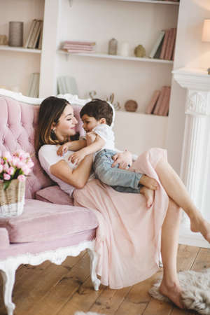 Mother with little son spending happy family time at home smiling and huggingの写真素材