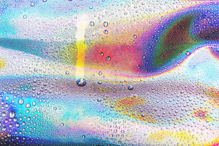 Drops of water on vibrant holographic neon background