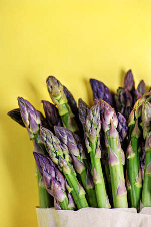Green asparagus on yellow background