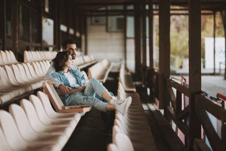 Thoughtful man and woman sitting together on empty sports tribune