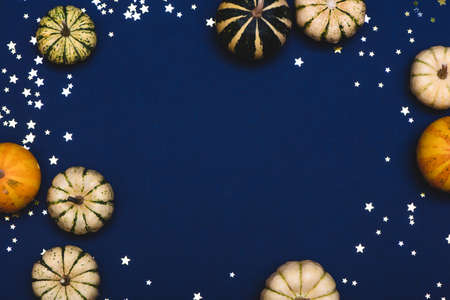 Decorative pumpkins and little stars on blue background.の写真素材