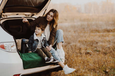 Mother with little son having picnic in car trunk.の写真素材
