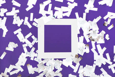 Creative layout with white frame and silver confetti on violet background.の写真素材