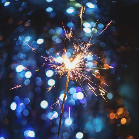 New Year background with sparkler and Christmas light bokeh.の写真素材